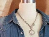 A buffalo nickel medallion on a gold paper clip chain necklace, displayed on a mannequin.