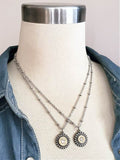 Two round stainless steel beaded bezel bullet pendants with stainless beaded chain, both displayed around neck of a mannequin.