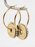 Close up of side view of 12 Gauge Shotshell Diamond Studded Gold Hoop Earrings hanging on wire