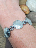 Genuine buffalo nickel link bracelet shown on wrist.