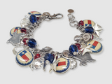 Close up of Texas loaded charm bracelet showing vintage flag charms, pistol charms, puffy hearts, .45 Auto casings and silver stars