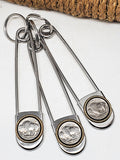 Genuine buffalo nickel jumbo safety pin keyrings on white background with rope in background.