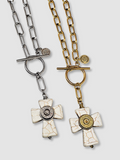 Two white howlite cross necklaces, one in gold and the other in silver, each mounted with coordinating silver and brass bullet casings.  Necklaces have toggle clasp closures and are shown on a white background.