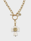 White howlite cross necklace shown on a white background.  Necklace has gold paperclip chain, toggle clasp and a brass bullet casing mounted in the center of the cross.  Shown on a white background.