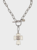White howlite cross necklace shown on a white background.  Necklace has stainless steel paperclip chain, toggle clasp and a nickel bullet casing mounted in the center of the cross.  