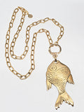 Full view of brass fish necklace with chunky gold paperclip chain, lobster clasp, SureShot logo tag, and front ring fastener.