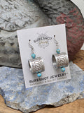 Goose band earrings displayed on SureShot Jewelry card with genuine aluminum bird bands, turquoise beads and stainless steel ear wires.  Earring card is leaning against a vintage duck decoy and sitting on a flat blue marble stone.